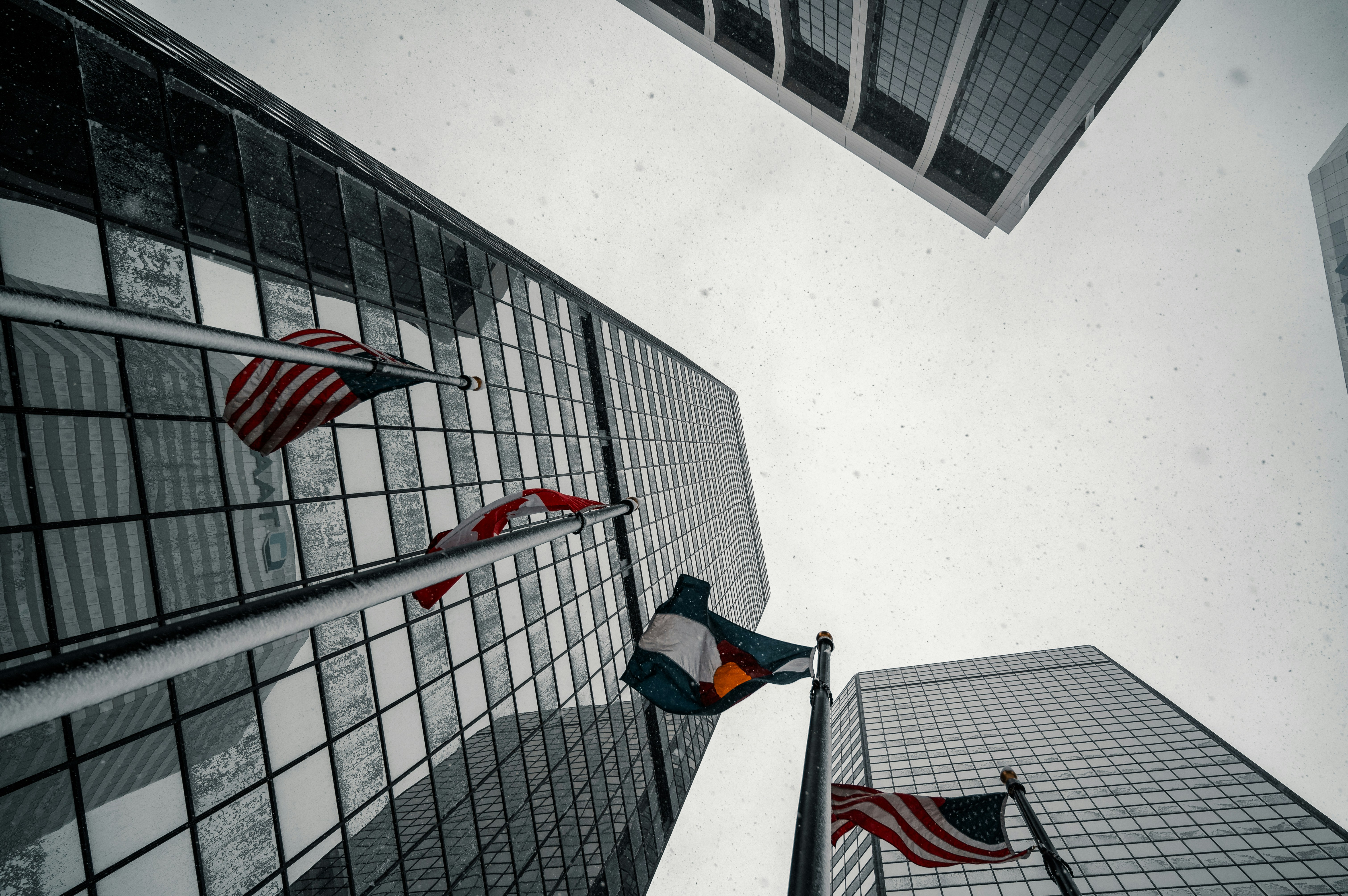 man in orange shirt and black pants standing on black metal fence
